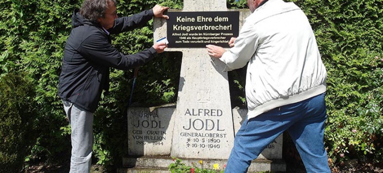 Die Künstler beim Anbringen des Mahnschildes